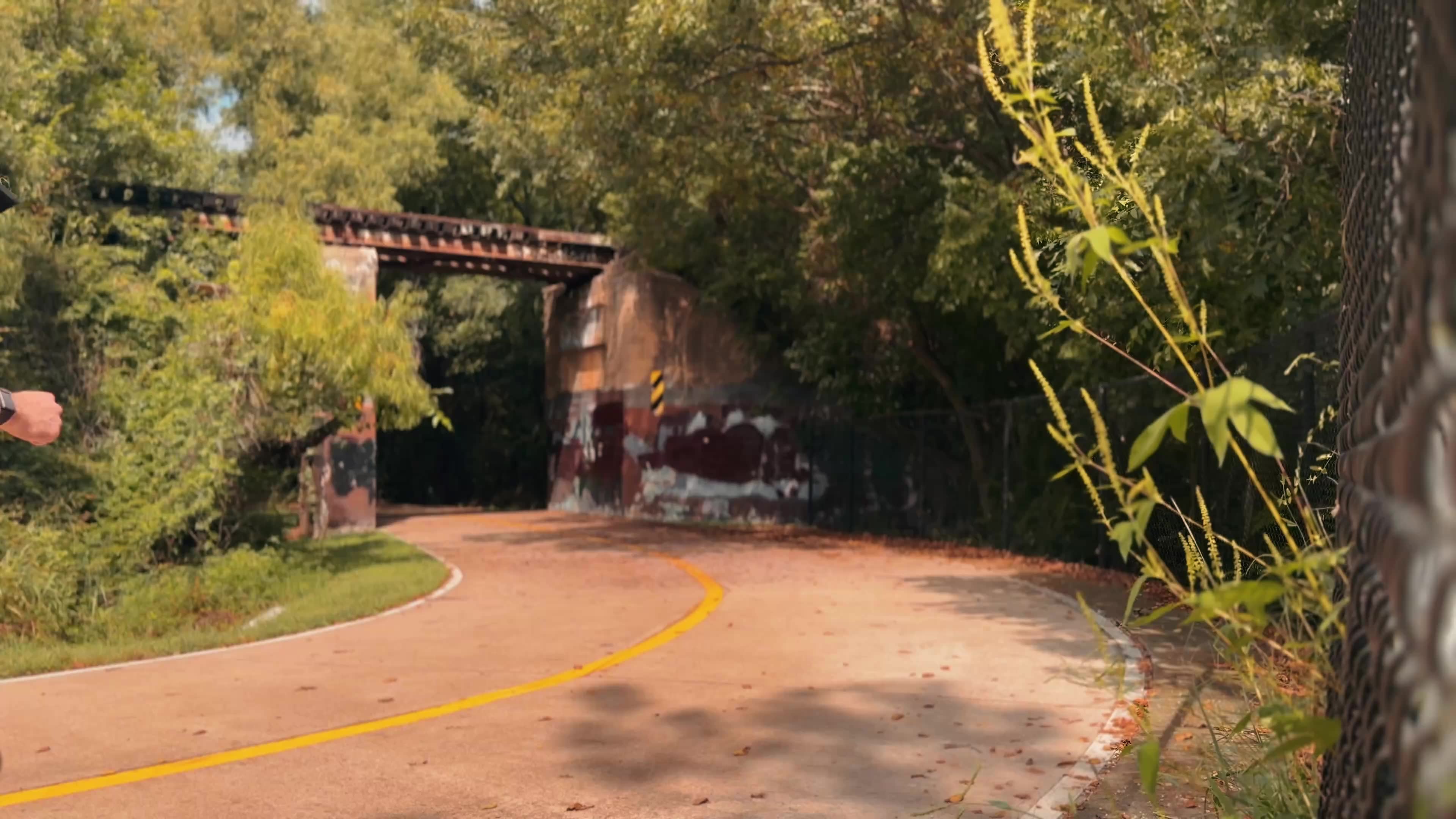 Vincent Alves running along a Texas trail under a railroad bridge